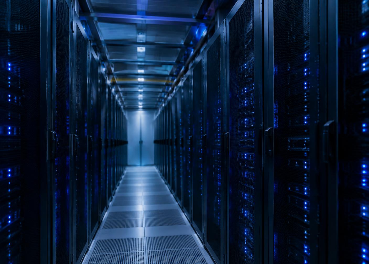 Corridor of server racks lit by blue indicator lights in a data center
